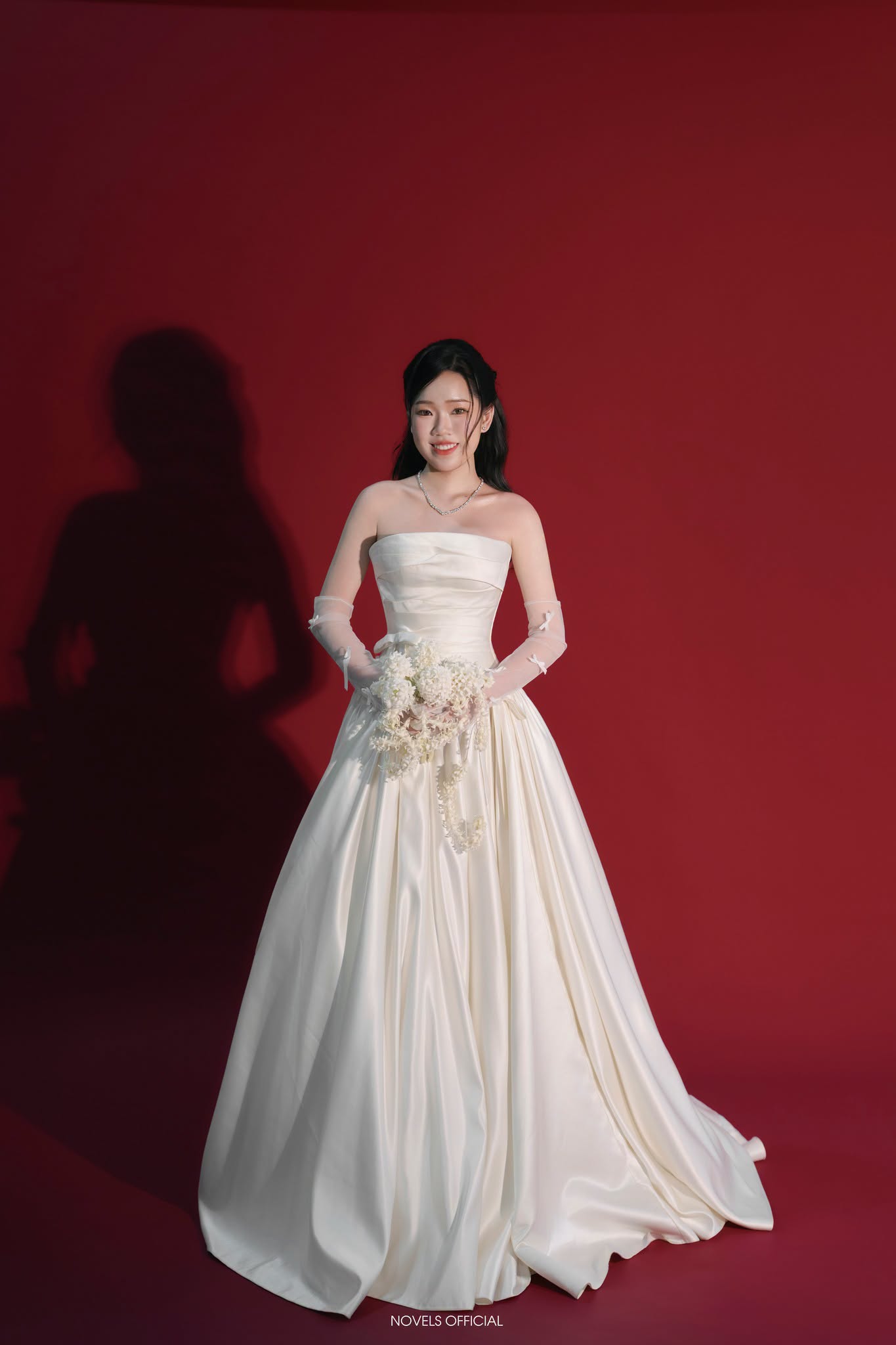 Mẫu váy cưới satin nổi bật trên nền studio phông đỏ